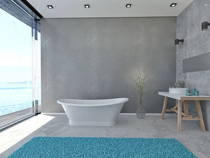 отдельно стоящая ванная с голубым мохнатым ковром